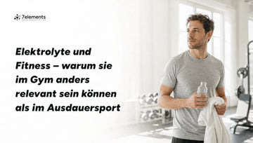 Mann im hellen Fitnessstudio mit Handtuch und Trinkflasche – Elektrolyte und Fitness
